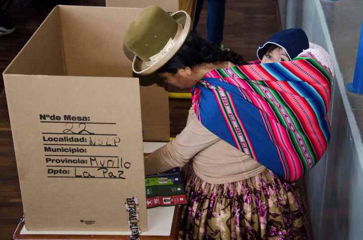 A woman marks her ballot paper at a pooling station in La Paz